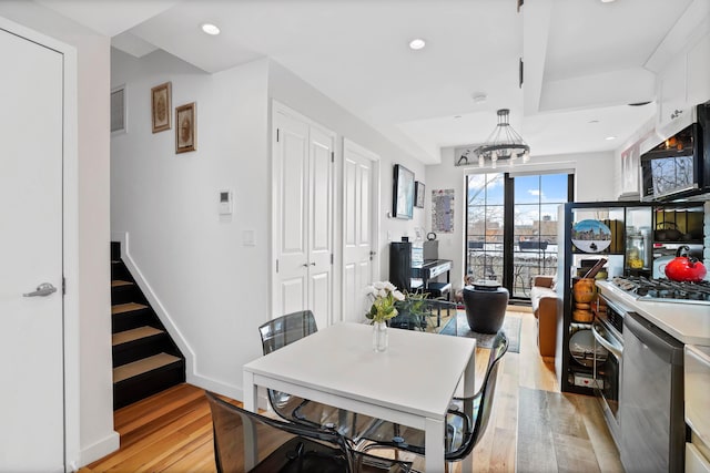 577 Madison St Unit 4B, New York City, NY 11221 - dining area featuring light wood-type flooring, stairs, a chandelier, recessed lighting, and baseboards