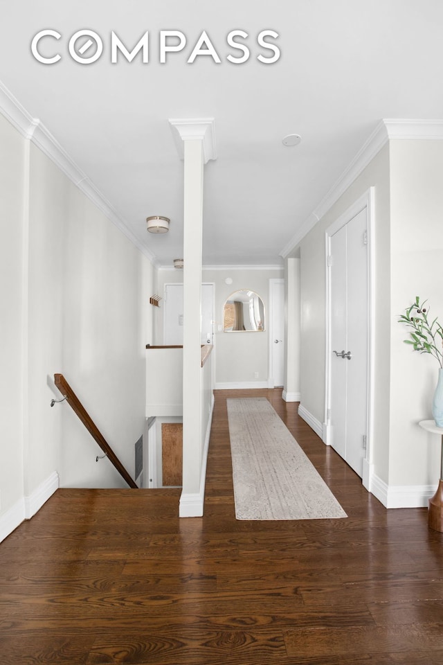 unfurnished living room with ornate columns, dark wood-style flooring, baseboards, and crown molding