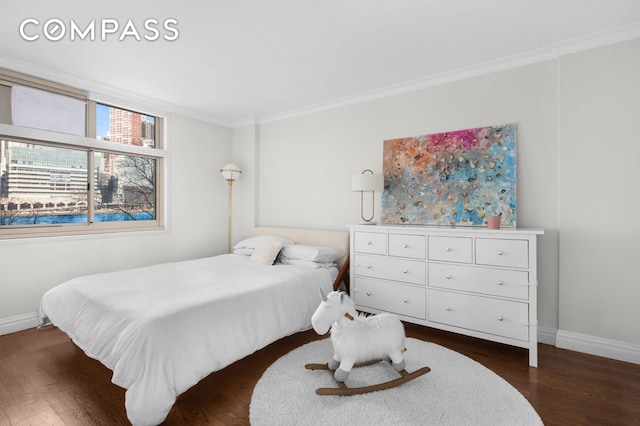 bedroom featuring baseboards, ornamental molding, and dark wood finished floors