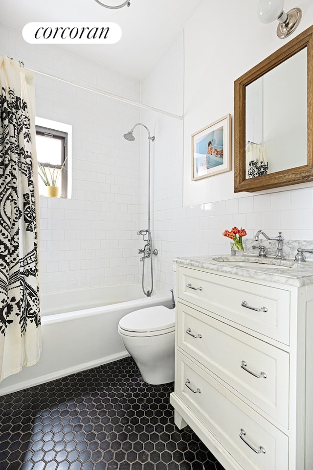 full bath with toilet, shower / tub combo, vanity, and tile walls