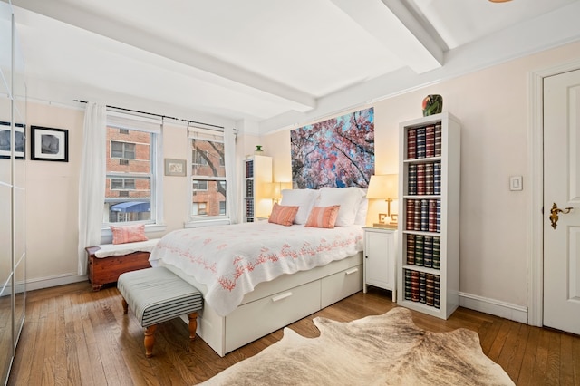 bedroom with light wood-style floors, baseboards, and beam ceiling