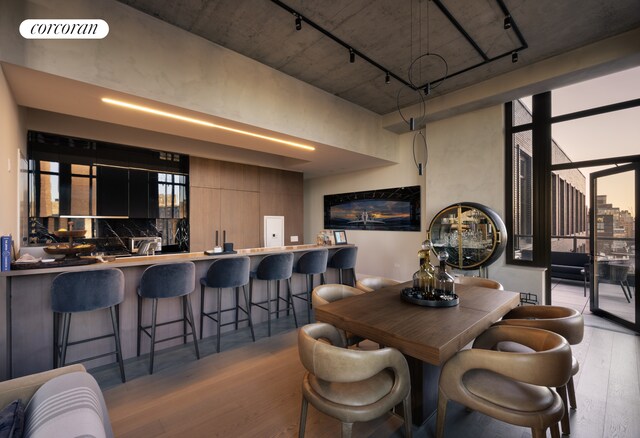 dining space featuring visible vents, a healthy amount of sunlight, rail lighting, and wood finished floors