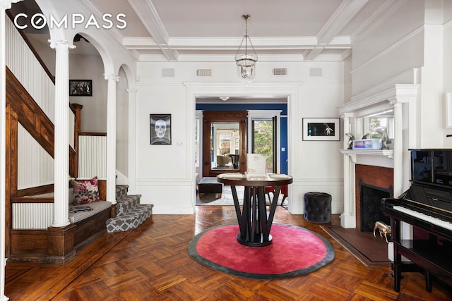 foyer entrance featuring a fireplace, stairway, coffered ceiling, and arched walkways