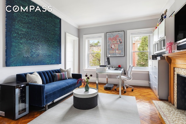 living area featuring plenty of natural light, a fireplace, baseboards, and crown molding