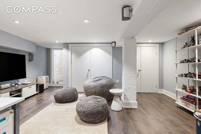 living area with baseboards, wood finished floors, and recessed lighting