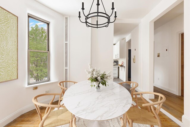 626 E 14th St Unit 11/12, New York City, NY 10009 - dining room with a chandelier, light wood finished floors, and baseboards