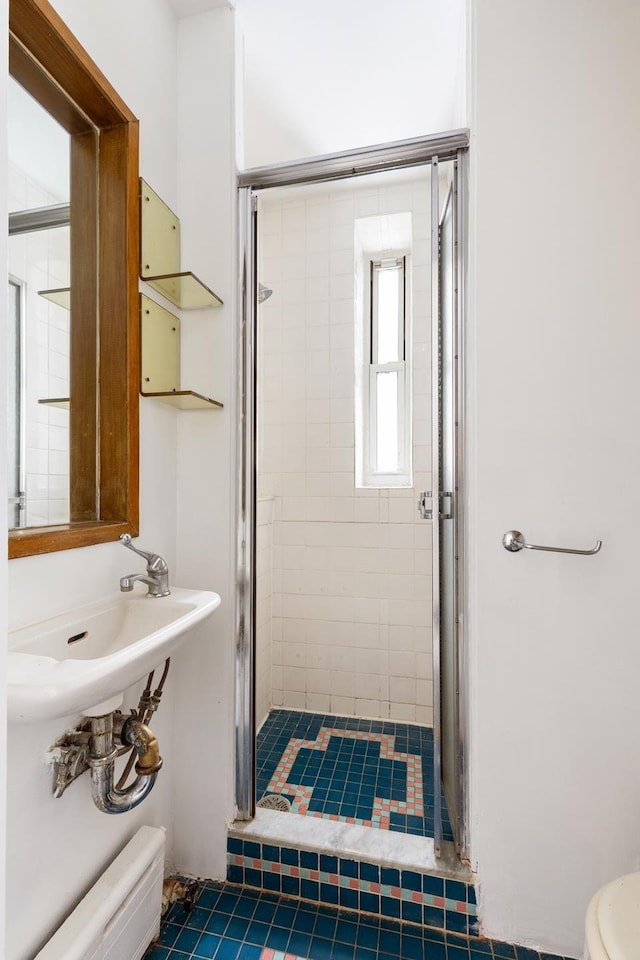 full bathroom with a baseboard heating unit, a shower stall, and toilet