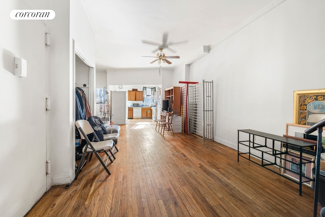 sitting room with a ceiling fan, dark wood-style flooring, and baseboards