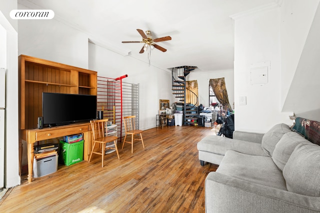 living area with crown molding, visible vents, stairway, ceiling fan, and hardwood / wood-style flooring