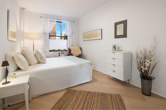 bedroom with baseboards and light wood finished floors