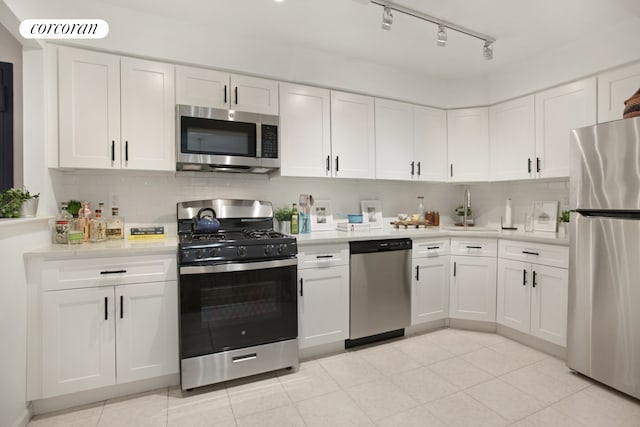 kitchen featuring backsplash, white cabinetry, stainless steel appliances, and light countertops