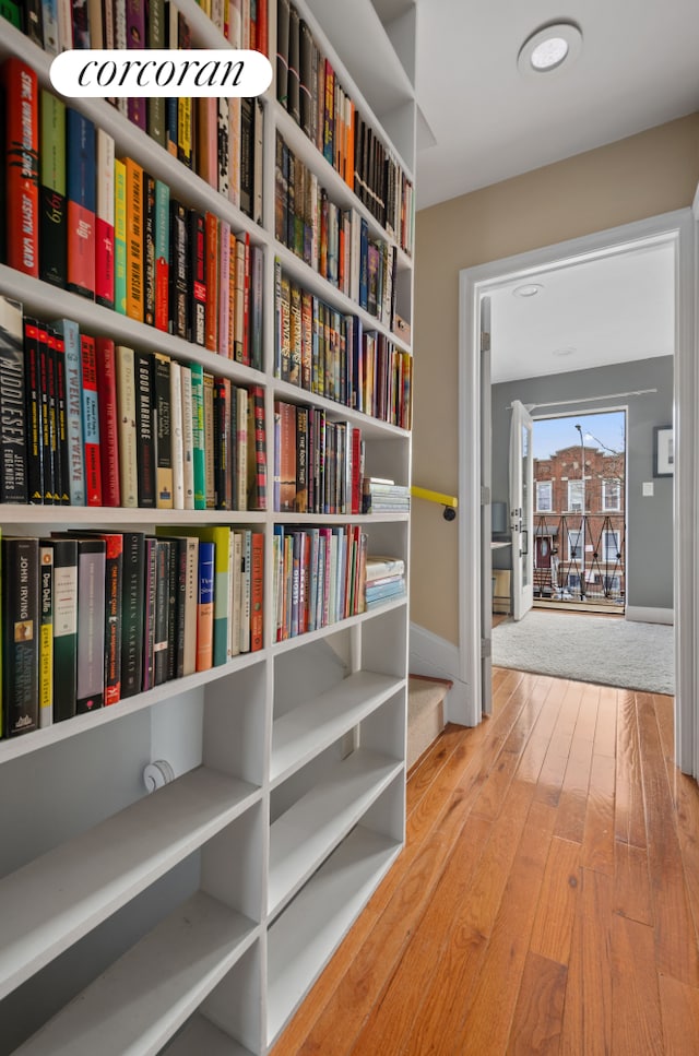 hallway featuring wood-type flooring and baseboards