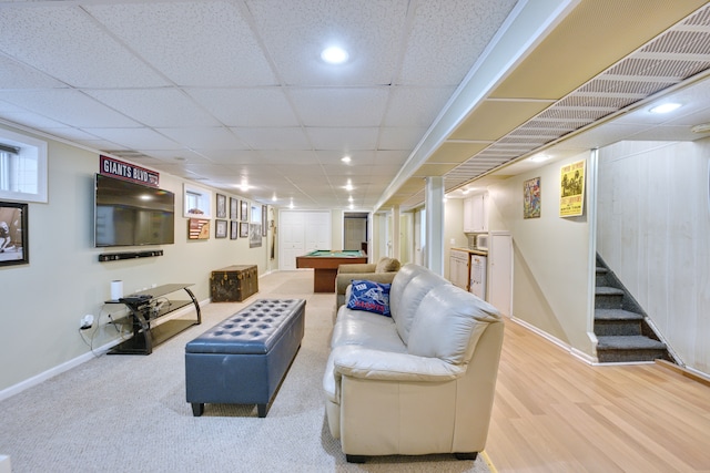 living room featuring a drop ceiling, pool table, wood finished floors, baseboards, and stairway