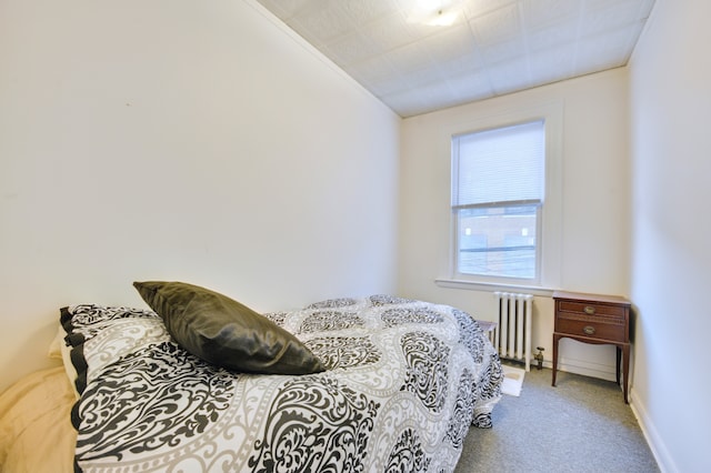 bedroom with carpet, radiator heating unit, and baseboards