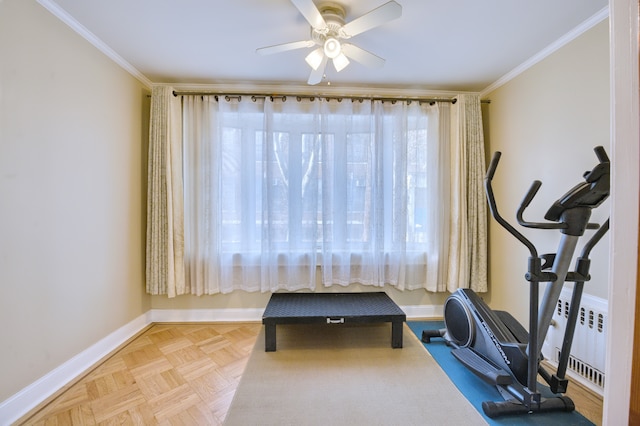 workout room featuring a ceiling fan, baseboards, crown molding, and radiator heating unit