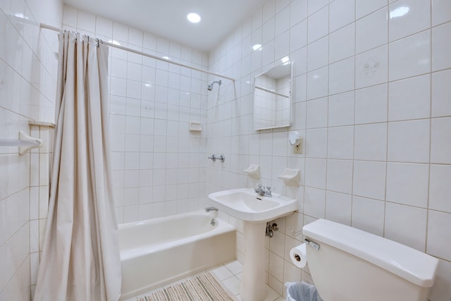 full bathroom featuring toilet, shower / bath combination with curtain, tile patterned flooring, and tile walls