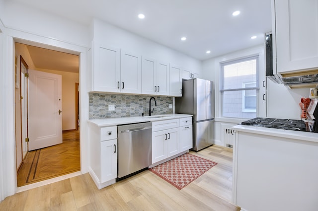 kitchen featuring stainless steel appliances, a sink, light countertops, and white cabinets