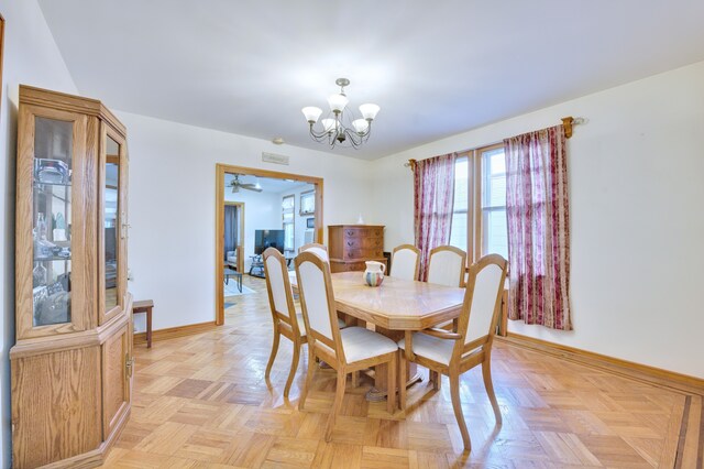 dining room featuring a notable chandelier and baseboards