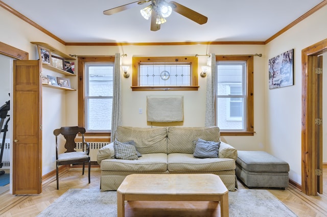 living room featuring baseboards, ornamental molding, and ceiling fan