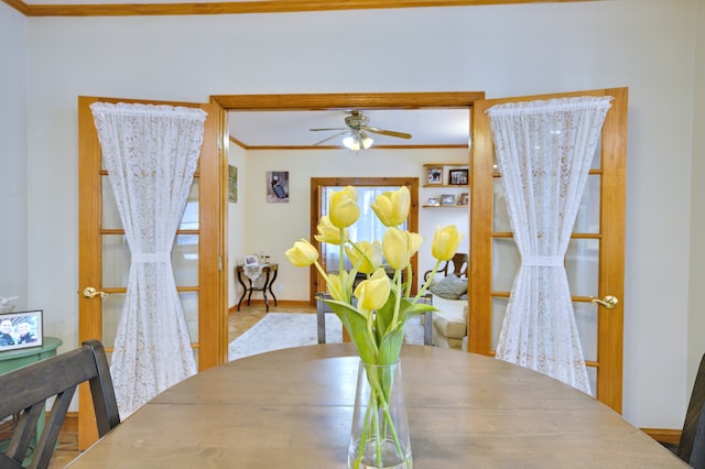 dining room featuring ornamental molding, a ceiling fan, and baseboards