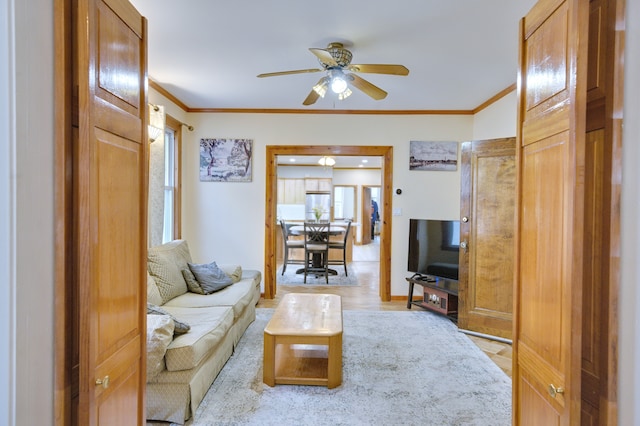 living room featuring ceiling fan, ornamental molding, and wood finished floors