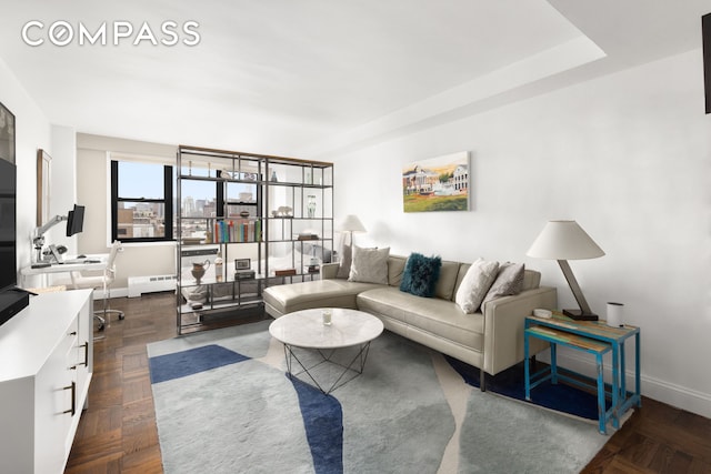 living room featuring baseboards and a baseboard heating unit