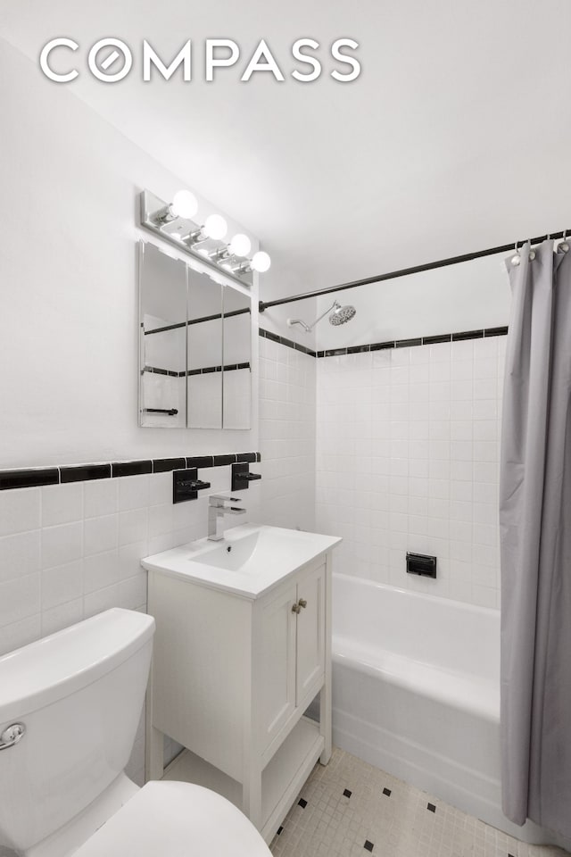 full bath featuring toilet, tile walls, shower / bath combination with curtain, and tile patterned floors