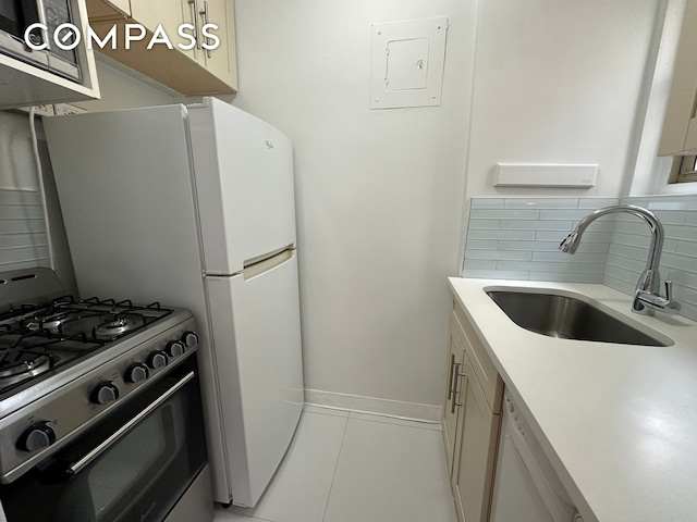 kitchen featuring light countertops, gas range oven, decorative backsplash, white dishwasher, and a sink