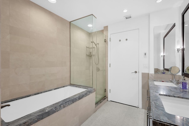 bathroom featuring tile patterned floors, visible vents, a stall shower, a sink, and a bath