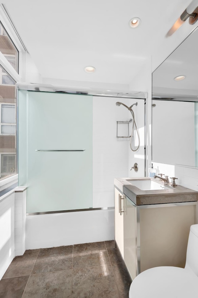 bathroom with enclosed tub / shower combo, toilet, vanity, and a ceiling fan