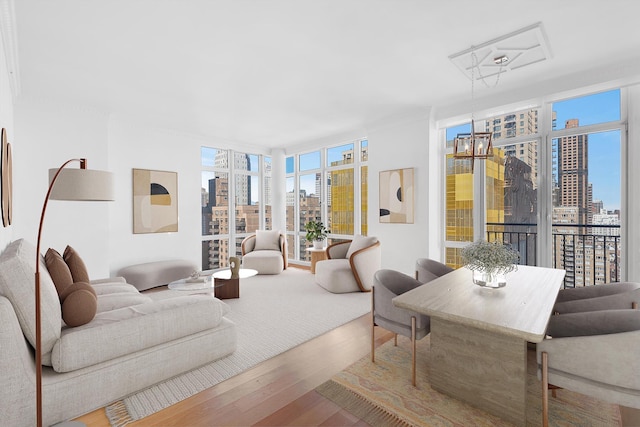 living room with a city view, floor to ceiling windows, and wood finished floors