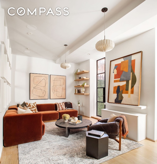 living area featuring baseboards and light wood-type flooring