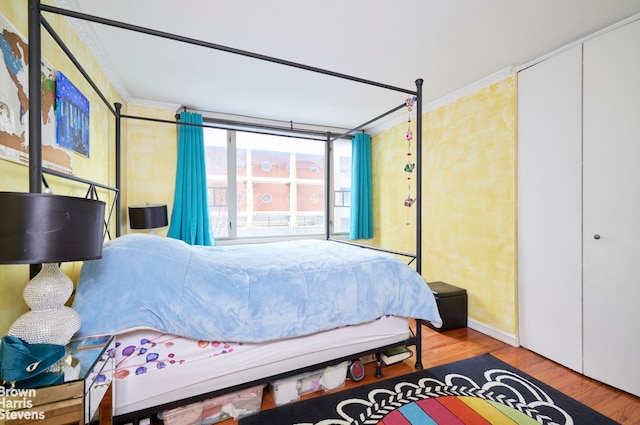 bedroom featuring ornamental molding and wood finished floors