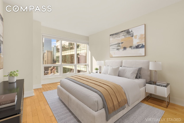 bedroom with light wood-style flooring and baseboards