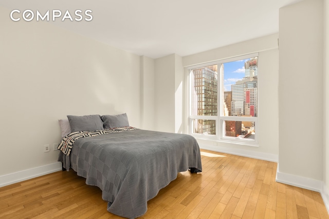 bedroom with light wood-style flooring and baseboards