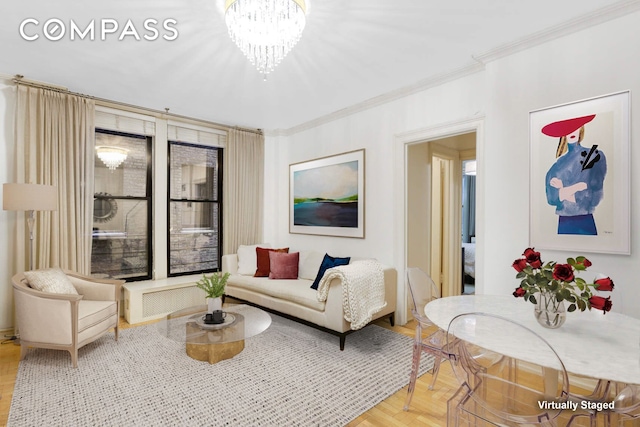 living area featuring ornamental molding, wood finished floors, and a chandelier