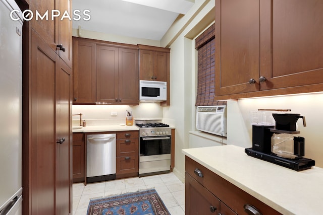 kitchen featuring a wall mounted air conditioner, appliances with stainless steel finishes, and light countertops