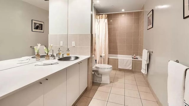bathroom with vanity, heating unit, toilet, tiled shower / bath combo, and tile patterned flooring