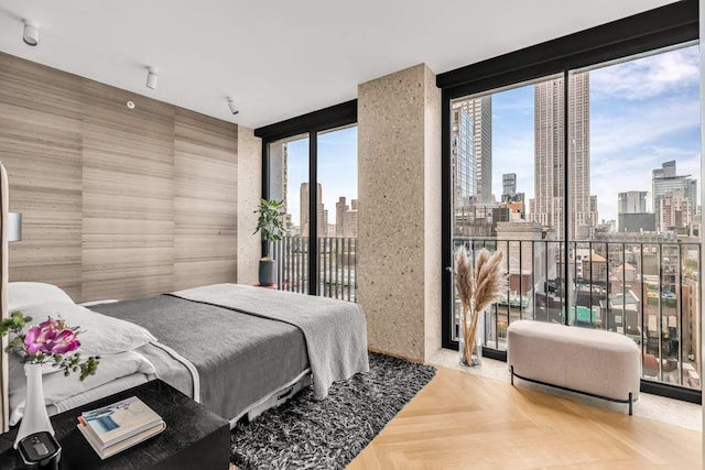 bedroom featuring a view of city, access to outside, and expansive windows