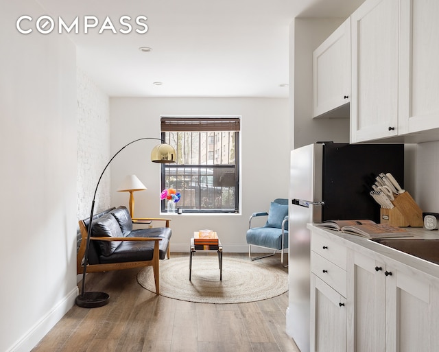 sitting room featuring light wood finished floors and baseboards