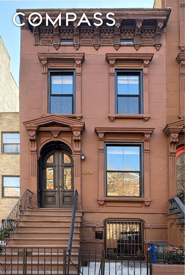 view of exterior entry with french doors and fence