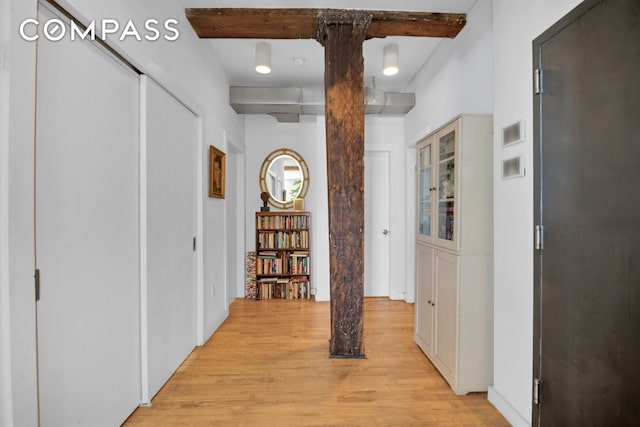 hall featuring light wood-style floors and beamed ceiling