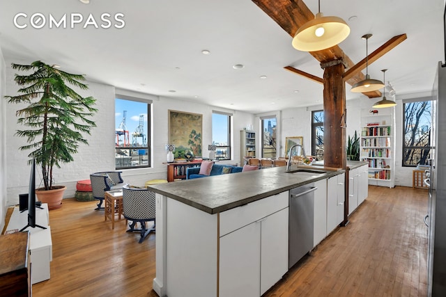 kitchen featuring dark countertops, a sink, dishwasher, and wood finished floors