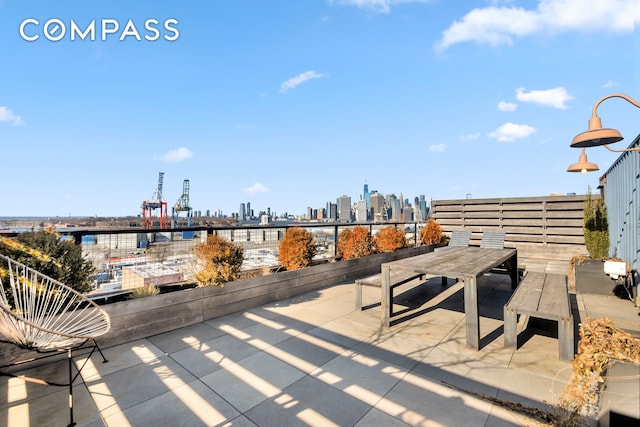 view of patio / terrace with a view of city and outdoor dining space