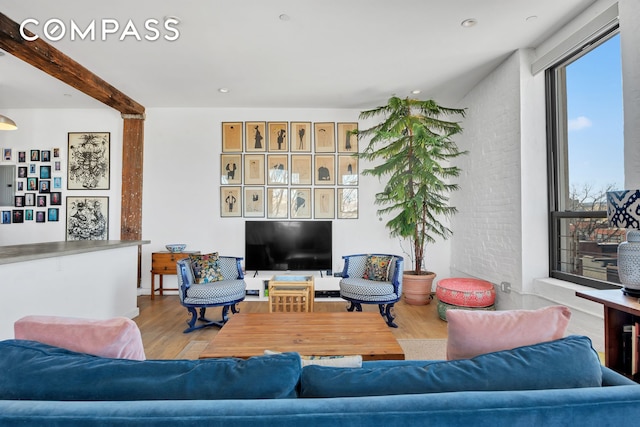 living area with recessed lighting, beamed ceiling, and wood finished floors