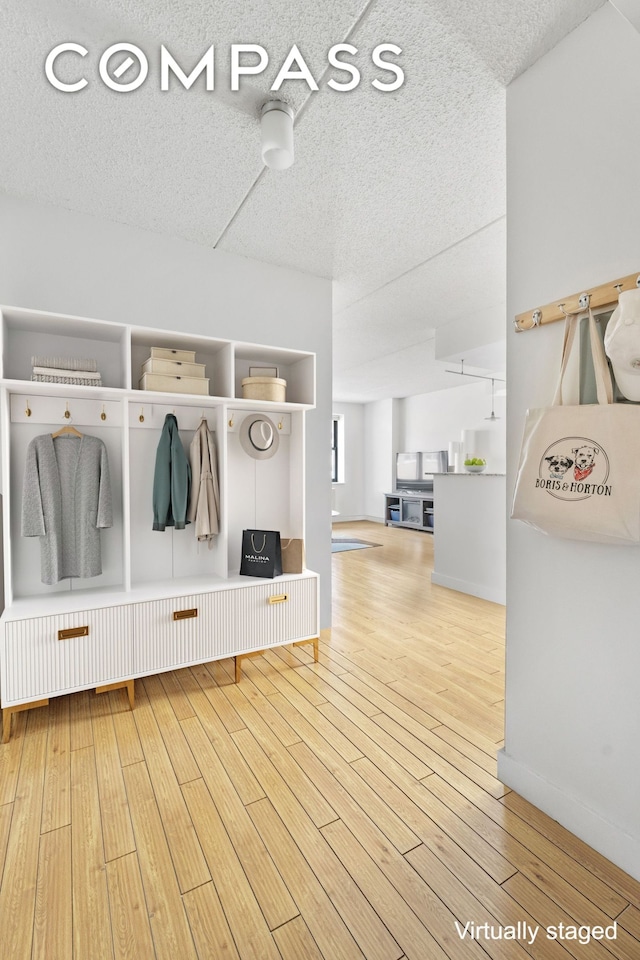 mudroom with a textured ceiling and wood finished floors