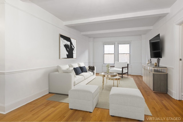 living room with light wood finished floors, beamed ceiling, and baseboards