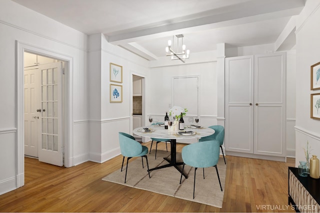 dining room with light wood finished floors, baseboards, and an inviting chandelier