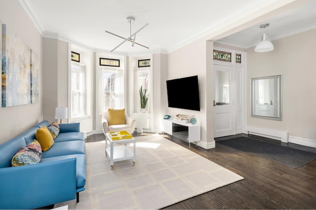 living area with crown molding, baseboards, and wood finished floors