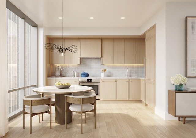 kitchen with backsplash, oven, light wood finished floors, and light countertops